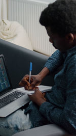 Midsection of man using mobile phone while sitting on table