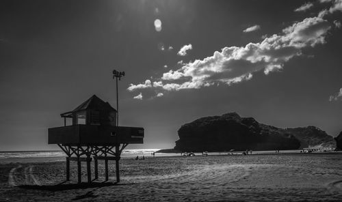 Lifeguard hut on beach by sea against sky