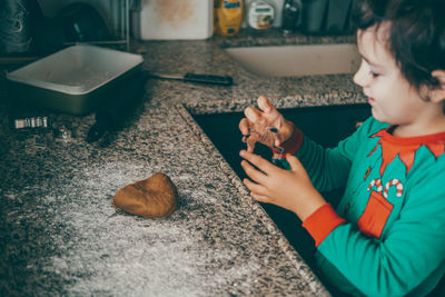 Boy and his mom create special memories while preparing christmas gingerbread for the joyful season.