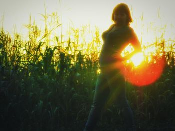 People on grassy field at sunset