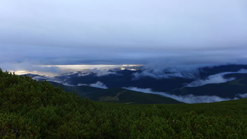 Scenic view of field and mountains against sky