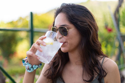 Young woman drinking gin and tonic at a party