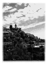 View of townscape and trees against sky