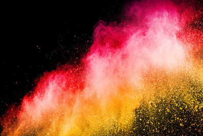 Defocused image of multi colored powder paints against black background