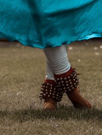 Low section of woman standing on field