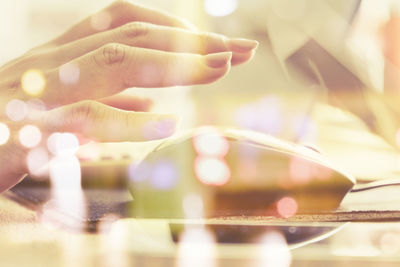 Close-up of human hand using mouse at desk