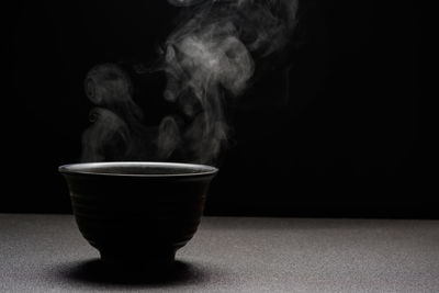 Close-up of coffee cup against black background