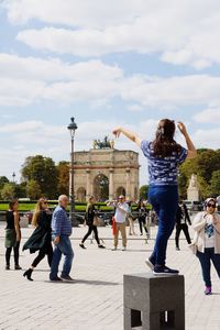 People walking in town square against sky