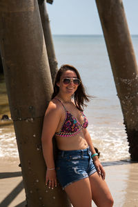 Woman standing against pier at beach