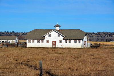 Built structure on field against blue sky