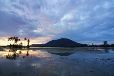 Scenic view of lake against sky at sunset