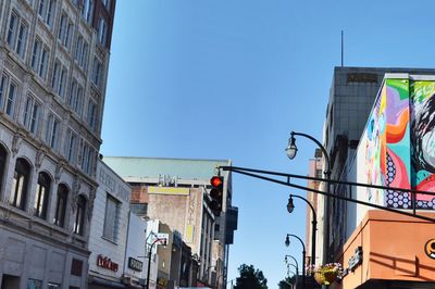 Low angle view of road signal against buildings