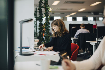 Young businesswoman using laptop at desk in office