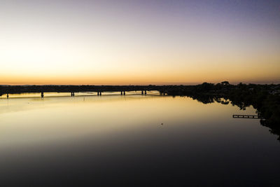 Scenic view of lake against clear sky during sunset