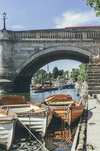 Bridge over river in city against sky