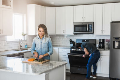 Woman standing in kitchen at home