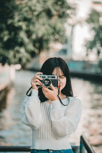 Portrait of young woman photographing