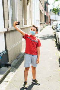 Full length of boy photographing with mobile phone