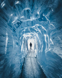 Rear view of person standing in snow cave