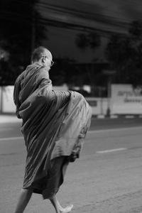 Monk walking on road in city