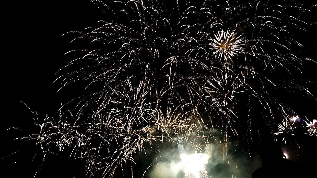 night, firework display, celebration, illuminated, exploding, firework - man made object, low angle view, arts culture and entertainment, glowing, sparks, motion, firework, sky, event, entertainment, celebration event, outdoors, light, no people, dark, multi colored