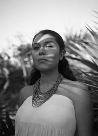 Portrait of young woman against grass