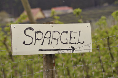 Close-up of sign on fence