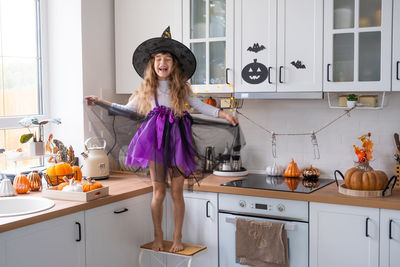 Side view of young woman standing in kitchen