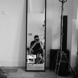 Man photographing while sitting on seat at home