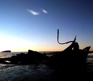 Silhouette of beach against sky during sunset