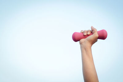 Midsection of woman holding hands against blue background