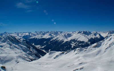 Scenic view of snow mountains against blue sky