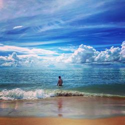 Rear view of man on beach against sky