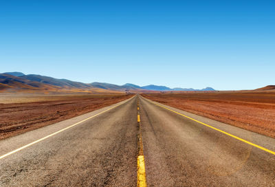 Road amidst desert against clear sky