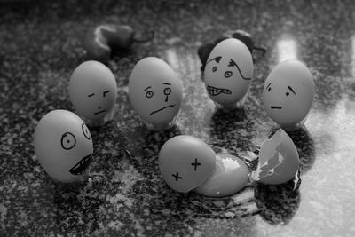 Various anthropomorphic faces on eggshells at table