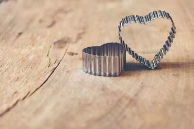 High angle view of heart shape pastry cutters on wooden table