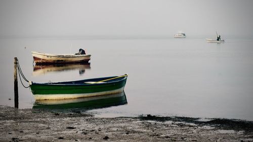 Boat moored on sea against sky