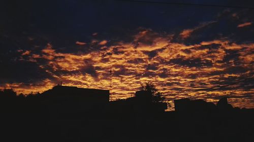 Silhouette buildings against sky during sunset