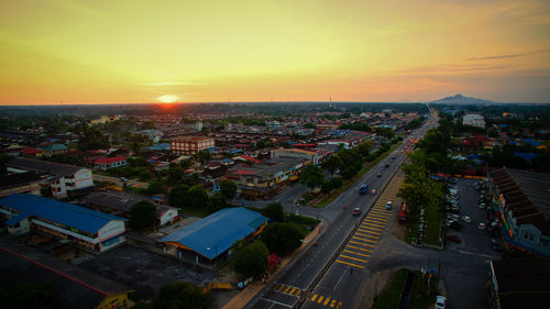 High angle view of street amidst buildings against sky during sunset