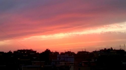 Buildings against cloudy sky at sunset