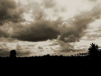 Silhouette landscape against cloudy sky