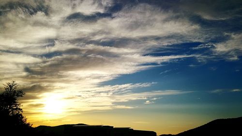 Silhouette of trees against dramatic sky