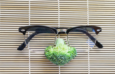 Close-up of anthropomorphic face made with eyeglasses and broccoli on place mat