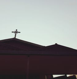 Low angle view of weather vane against sky