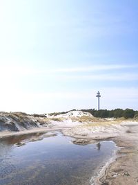 Lighthouse on land against sky