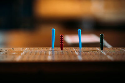 Multicoloured pegs on crib board, eye level.