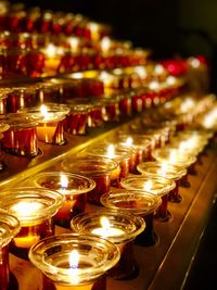 Close-up of illuminated candles in temple