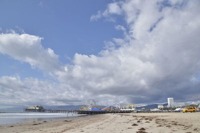 Distant view of santa monica pier at beach against sky