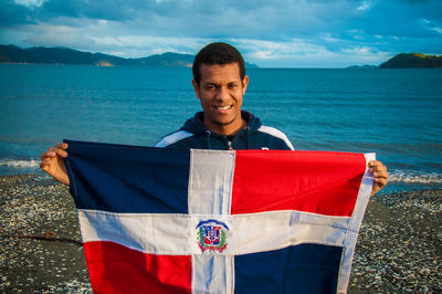 Portrait of smiling mid adult man in sea against sky