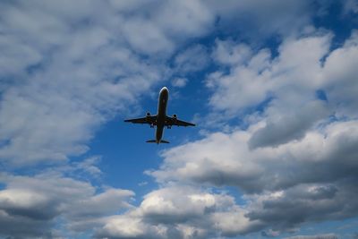 Low angle view of airplane flying against sky